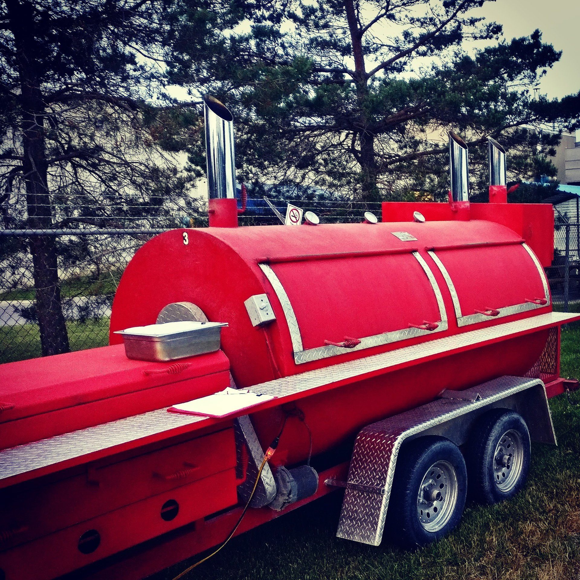 BBQ Feast mobile red smoker serving an outdoor catered event